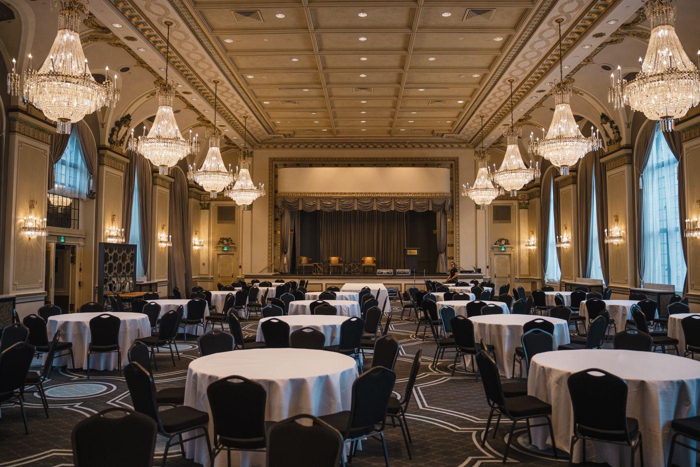 Ballroom set with round banquet tables under chandeliers