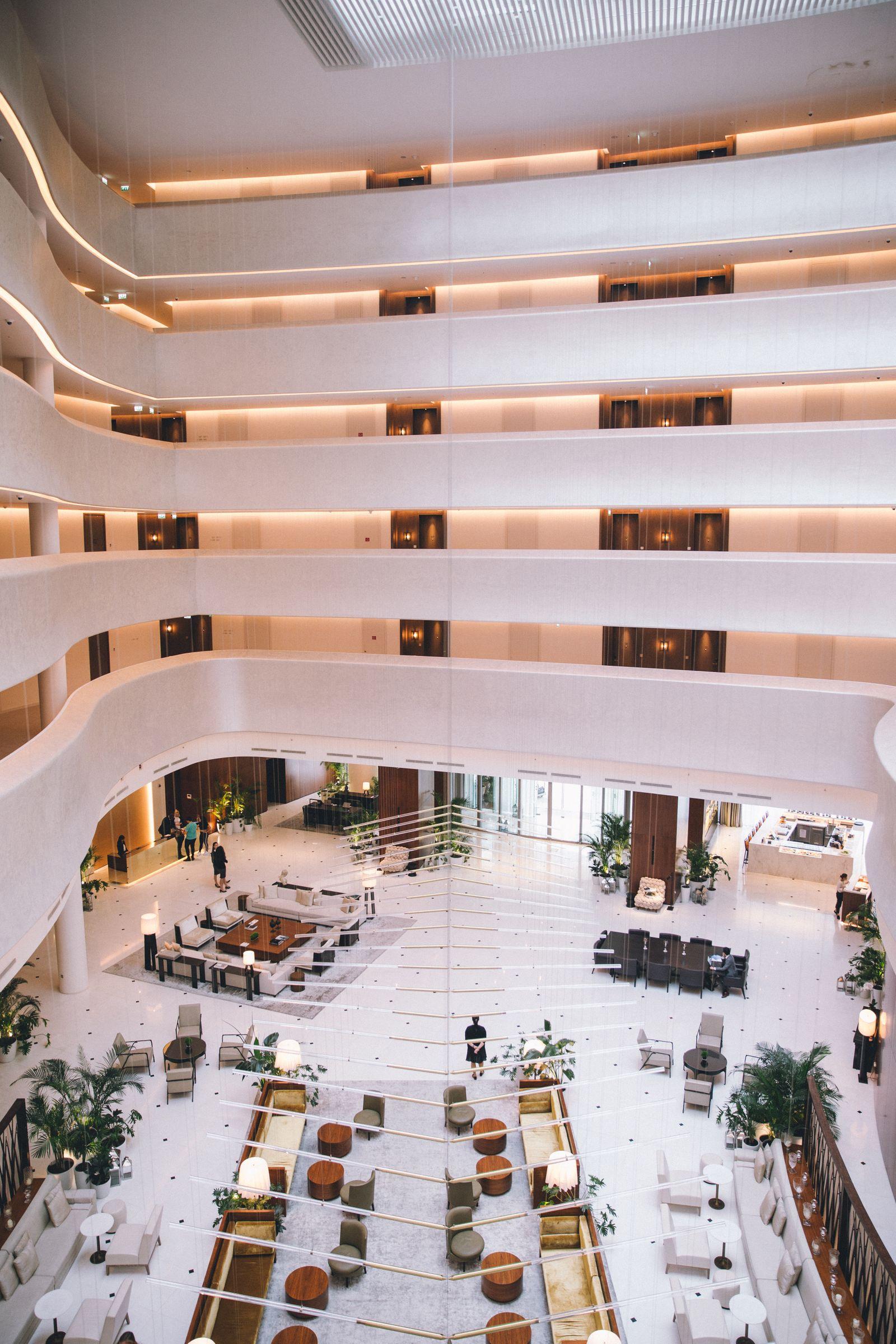 Looking down through the balconies of a multi-storey hotel atrium to the lobby below